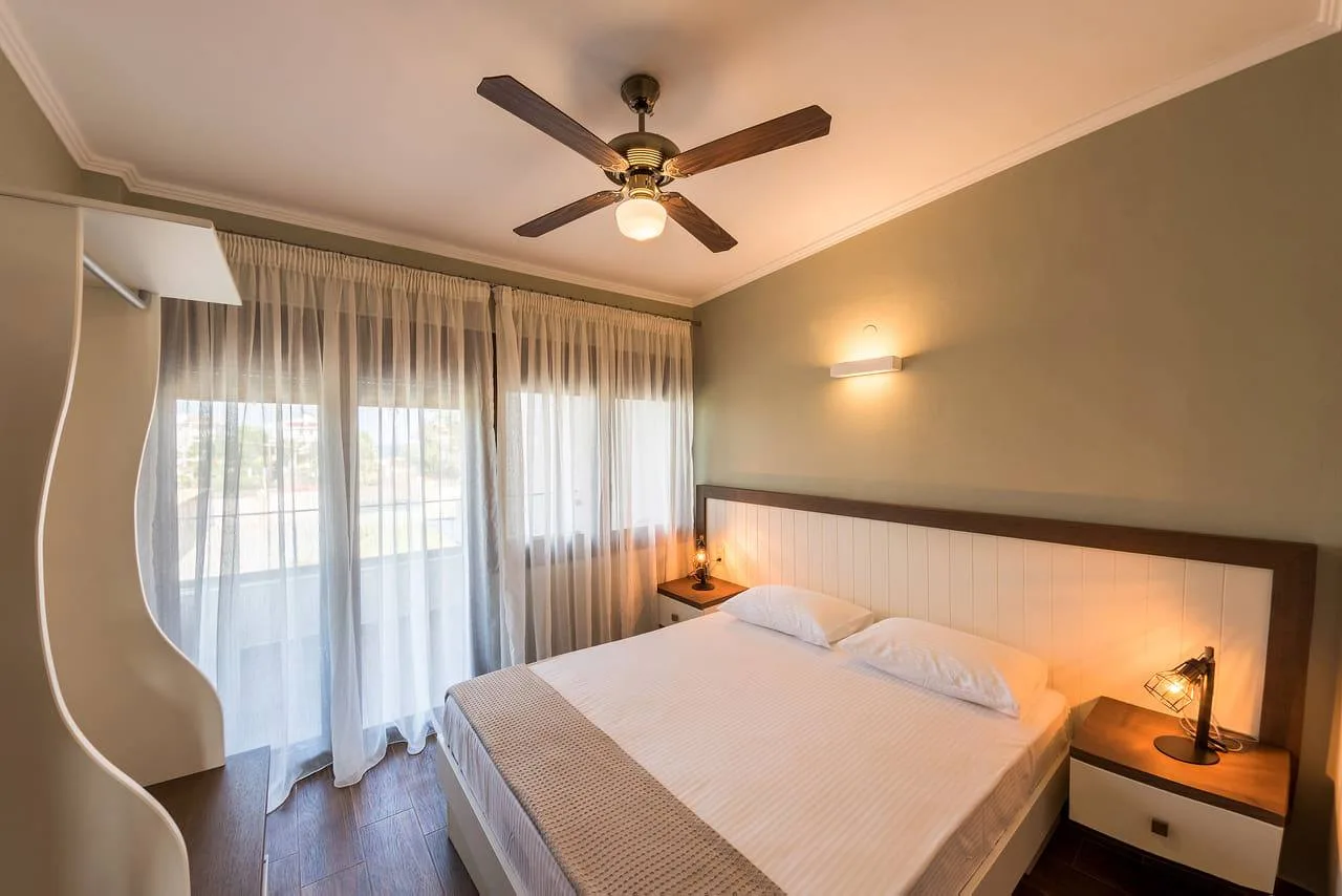 King bedroom with a balcony door and ceiling fan
