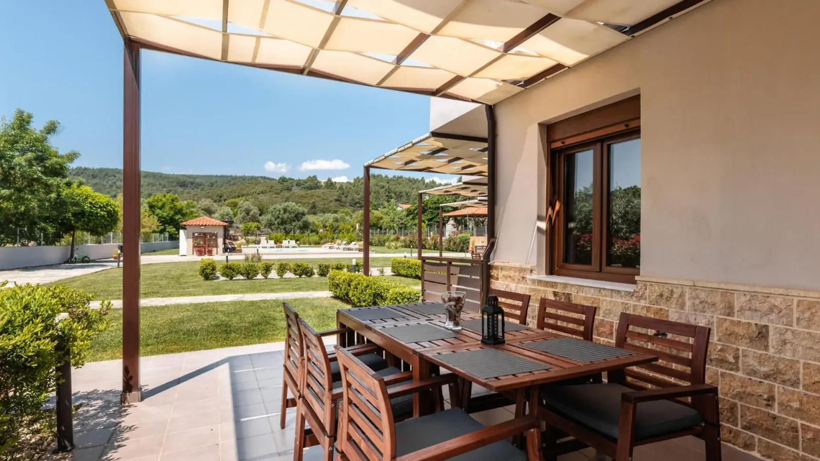 Private pergola terrace with a six-seat table, pool beyond